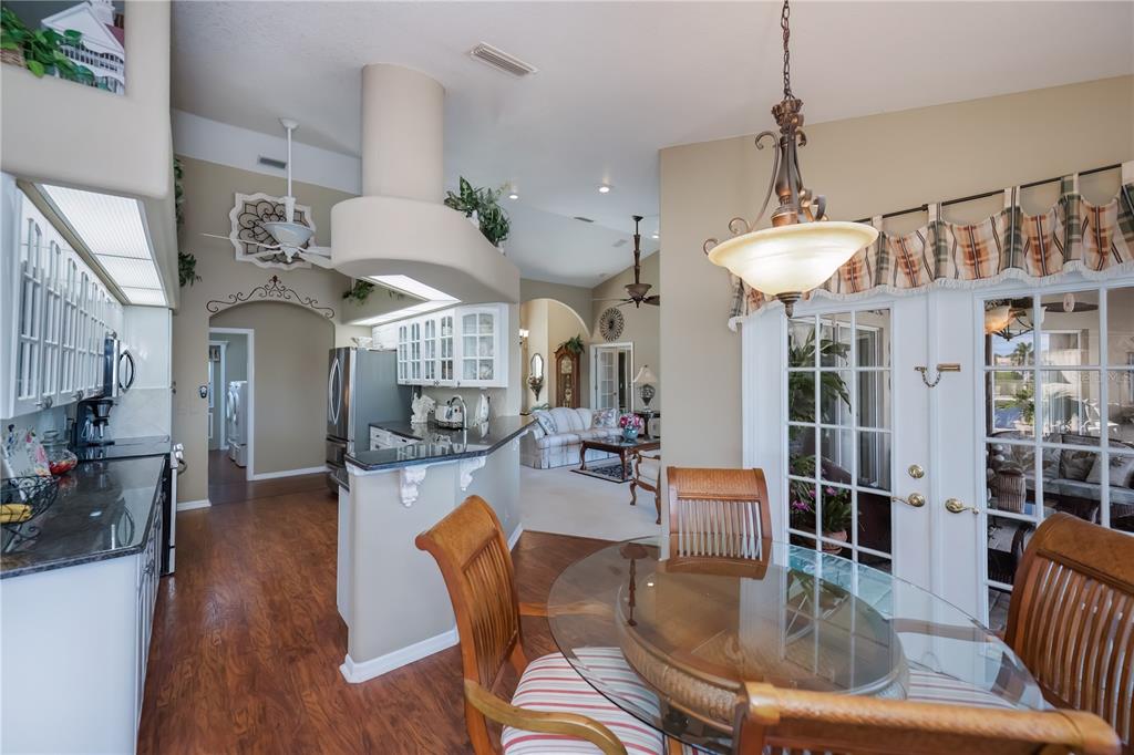 26373 Madagascar Road Punta Gorda, FL 33983 - Photo 28 of 90 a dining room with wooden floor a chandelier a wooden table and chairs