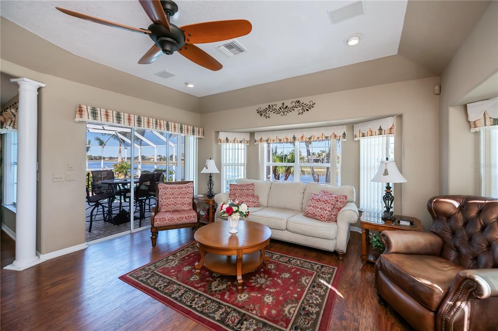 26373 Madagascar Road Punta Gorda, FL 33983 - Photo 32 of 90 a living room with furniture a rug and a chandelier