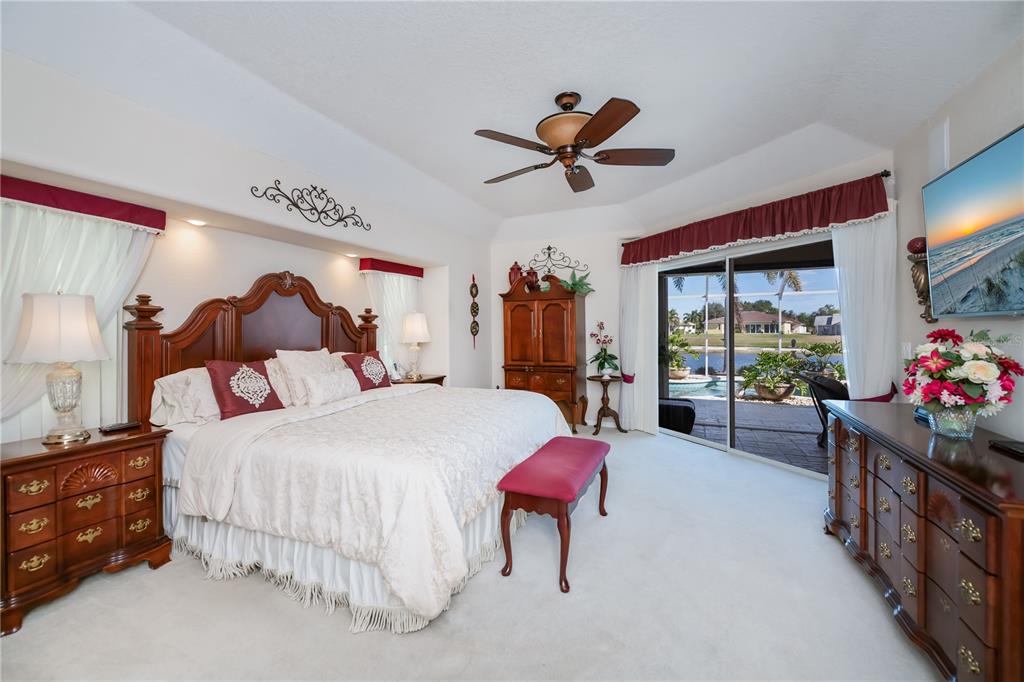 26373 Madagascar Road Punta Gorda, FL 33983 - Photo 33 of 90 a bedroom with a bed and a chandelier