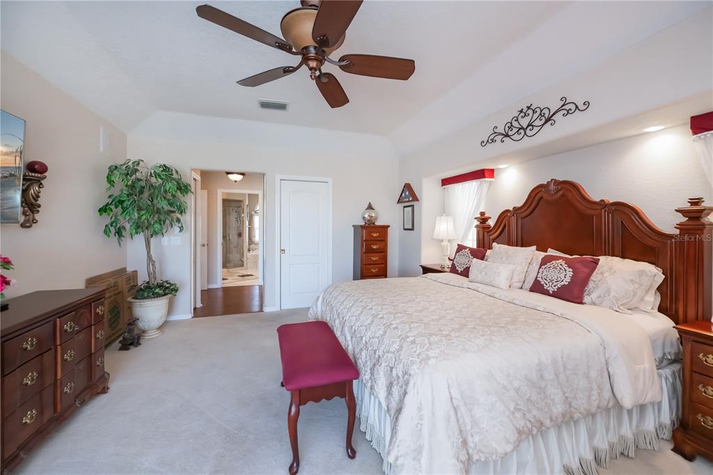 26373 Madagascar Road Punta Gorda, FL 33983 - Photo 36 of 90 a spacious bedroom with a bed a chandelier and a dresser