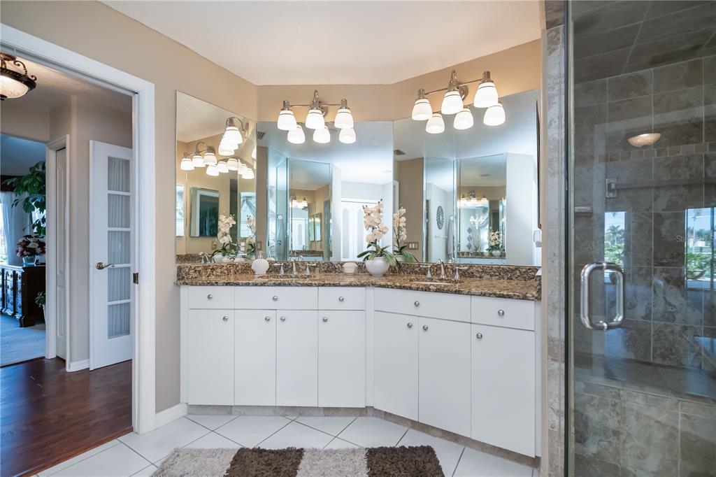 26373 Madagascar Road Punta Gorda, FL 33983 - Photo 39 of 90 a bathroom with a granite countertop sink a large mirror and a shower