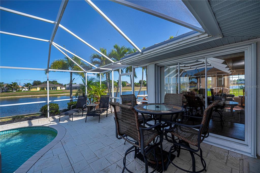 26373 Madagascar Road Punta Gorda, FL 33983 - Photo 60 of 90 a view of a patio with table and chairs under an umbrella