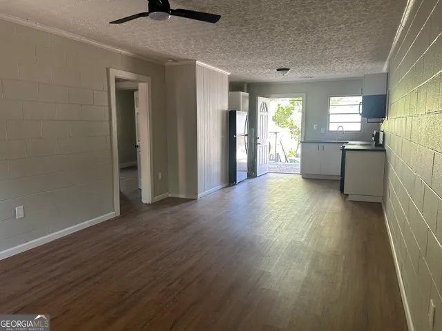 a view of a kitchen with wooden floor and a refrigerator