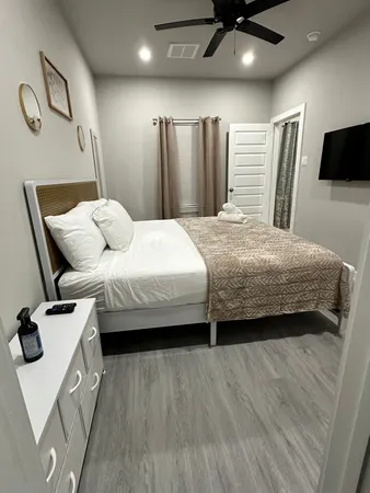 a bedroom with a bed window and a wooden floor