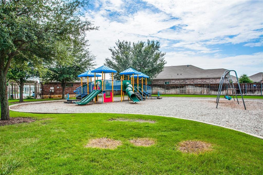 5817 Deck House Road Fort Worth, TX 76179 - Photo 19 of 19 Community playground featuring a multi-level play structure with slides, a swing set, and a wood chip surface