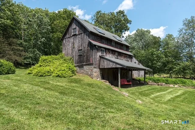 a front view of house with yard and trees in the background