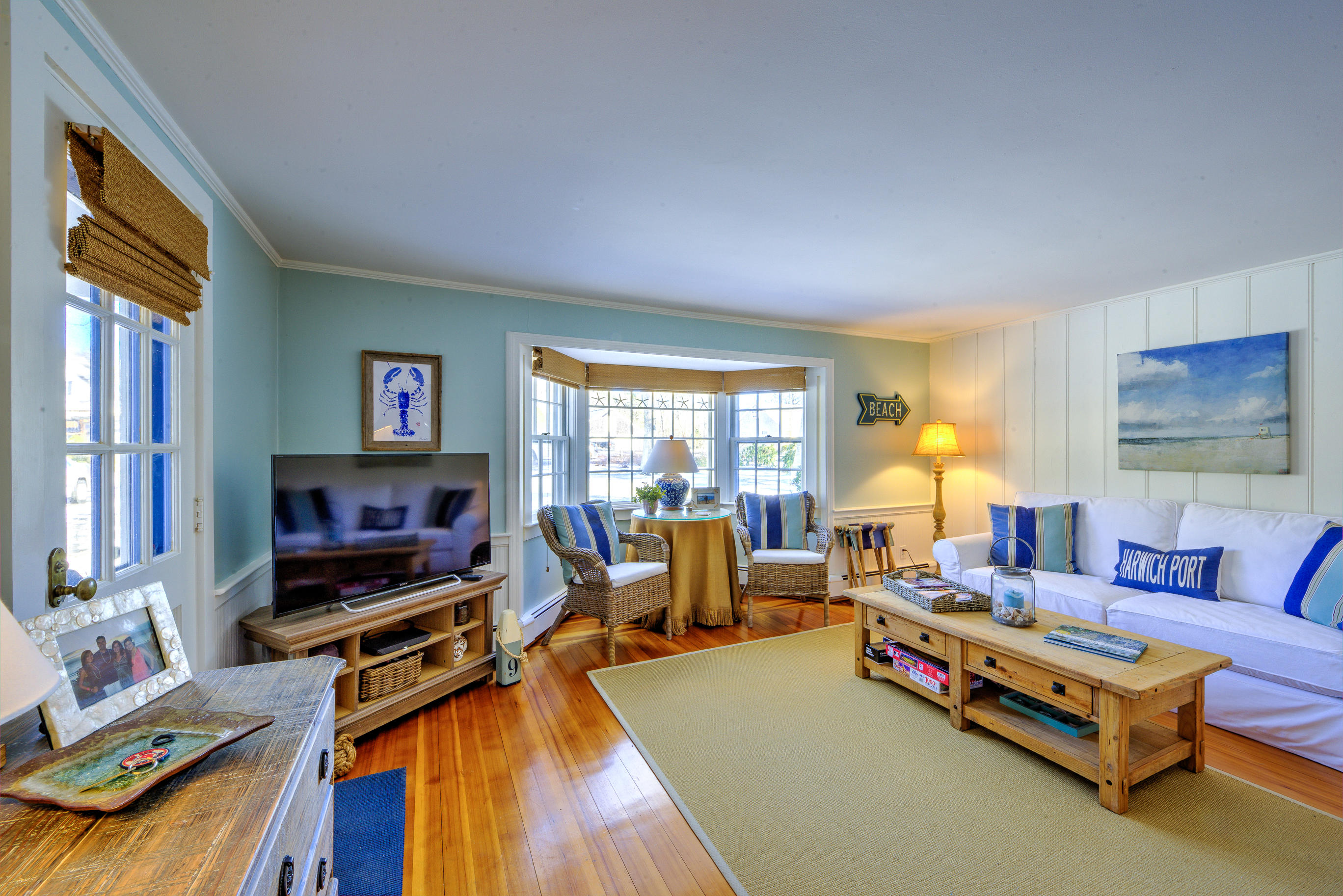 36 Deep Hole Road Harwich Port, MA 02646 - Photo 19 of 34 a living room with furniture a flat screen tv and a floor to ceiling window