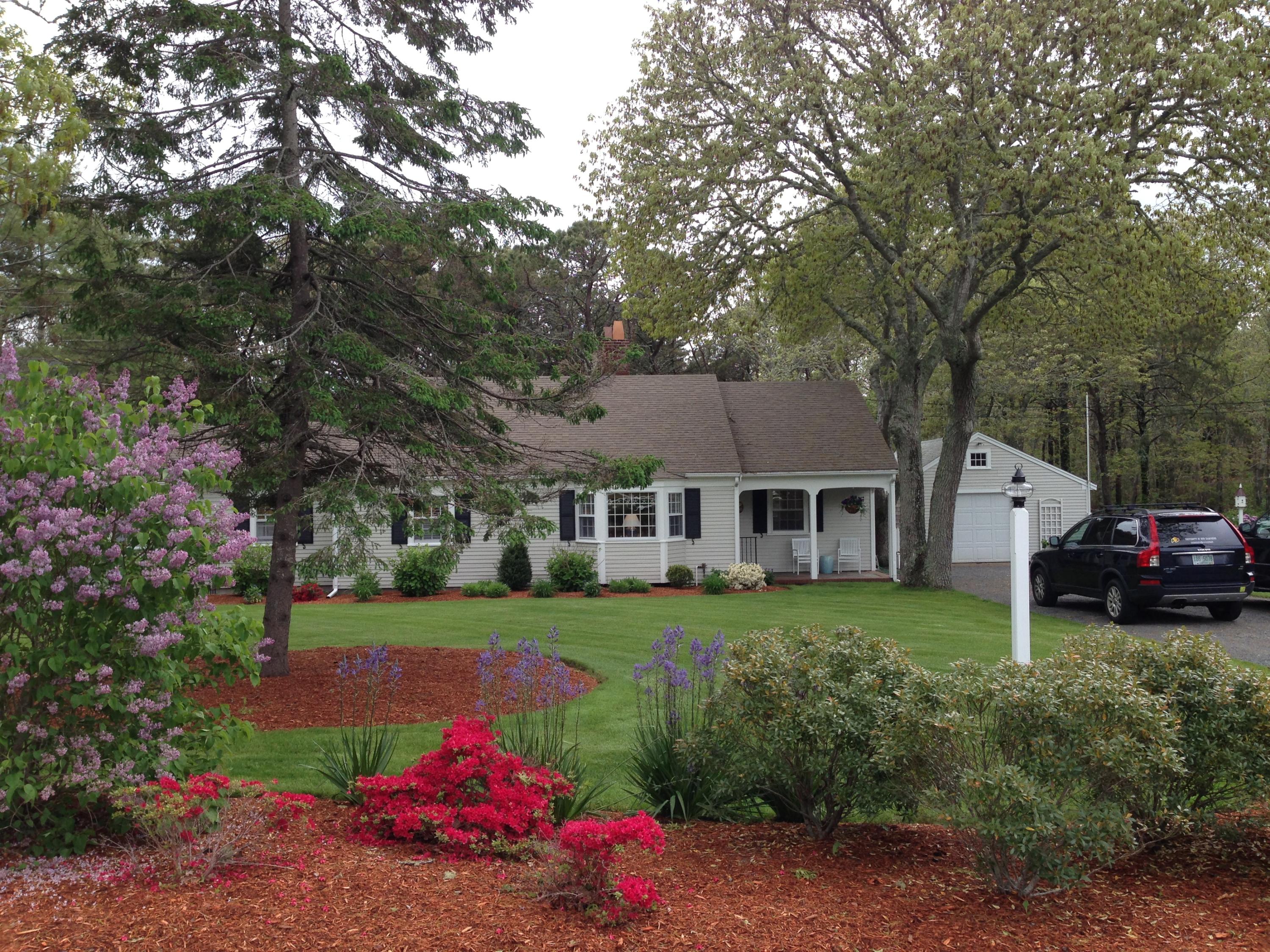 36 Deep Hole Road Harwich Port, MA 02646 - Photo 2 of 34 a front view of a house with a yard and garage