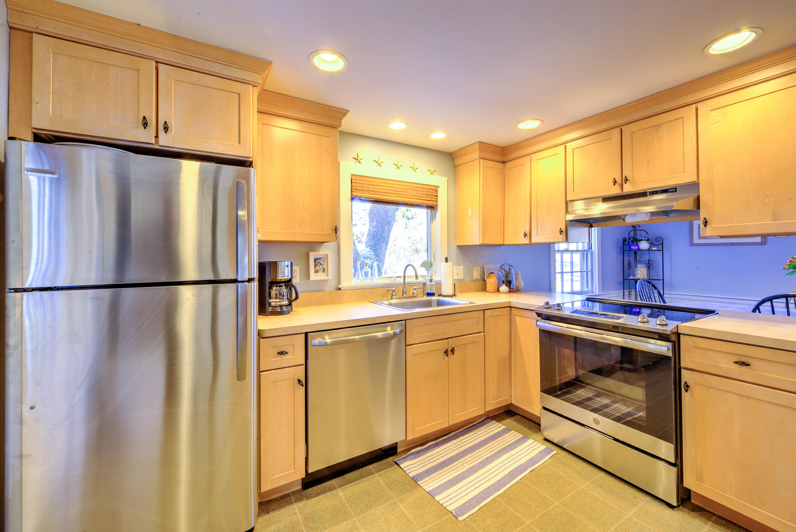 36 Deep Hole Road Harwich Port, MA 02646 - Photo 21 of 34 a kitchen with stainless steel appliances granite countertop a refrigerator a sink dishwasher a stove with white cabinets and wooden floor