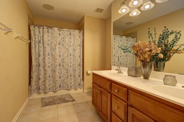 a bathroom with a granite countertop sink a mirror and a shower