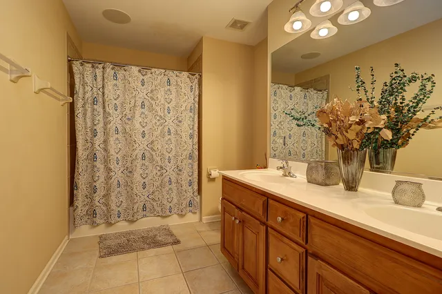 a bathroom with a granite countertop sink a mirror and a shower