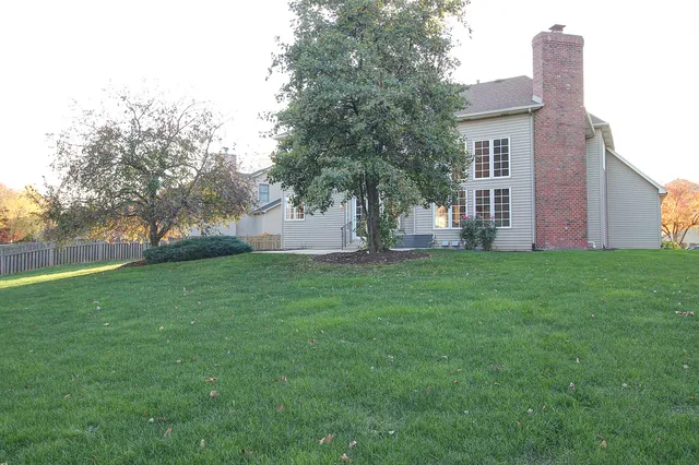 a view of a house with yard and a tree
