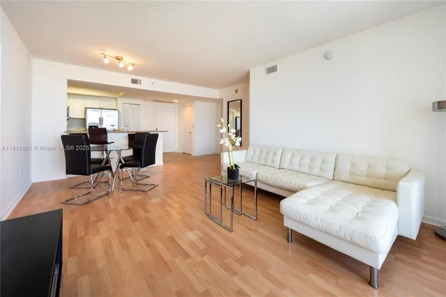 a living room with furniture and view of kitchen