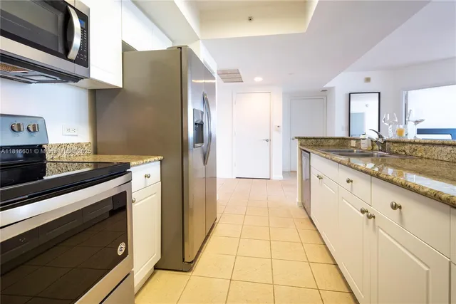 a kitchen with stainless steel appliances granite countertop a refrigerator and a stove