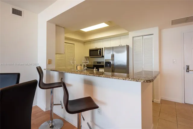 a kitchen with granite countertop cabinets and chairs
