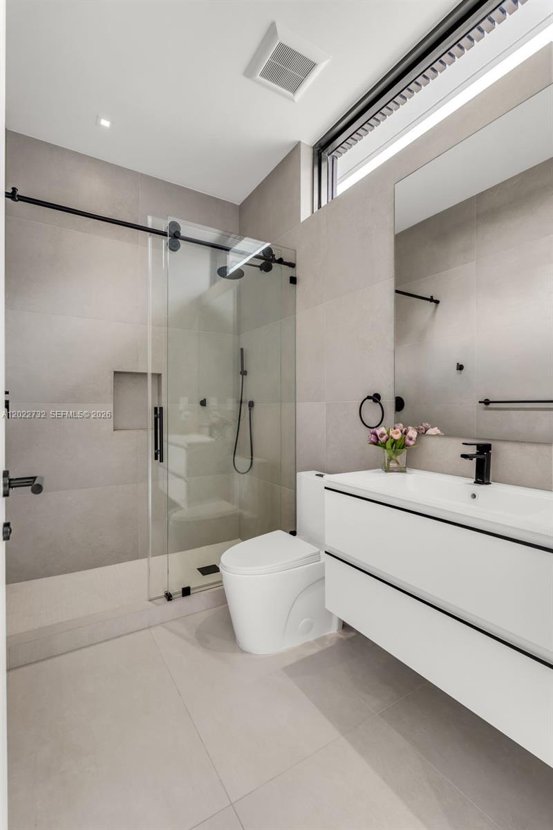 7825 Southwest 128th Street Pinecrest, FL 33156 - Photo 39 of 88 a bathroom with a sink mirror and shower