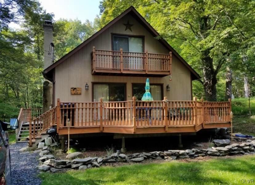 a view of a house with a yard and deck