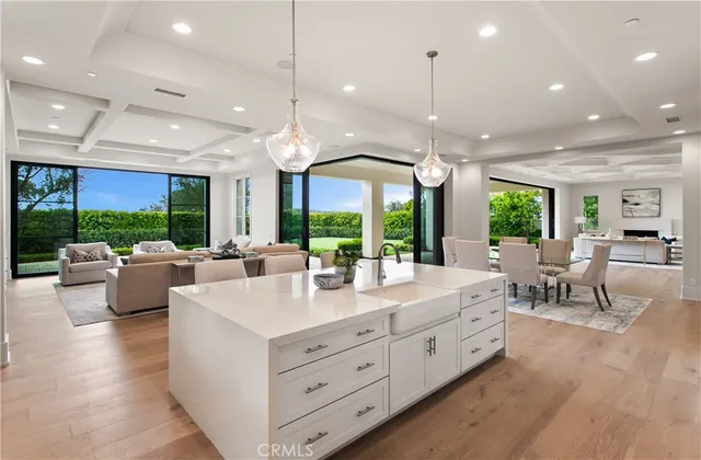 a large white kitchen with a large window and a wooden floor