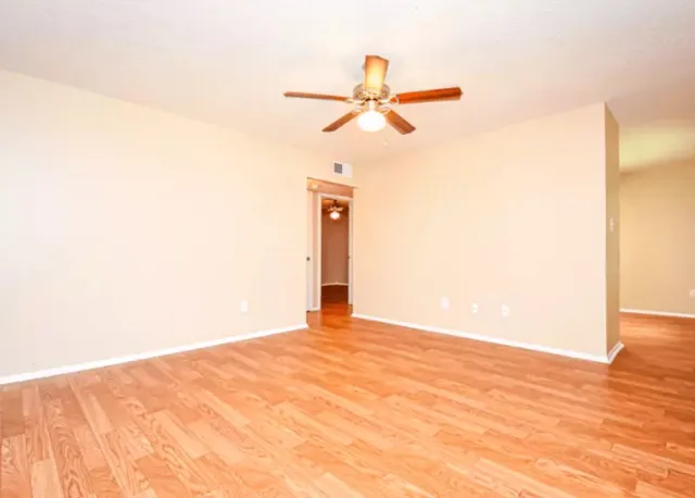 a view of a room with a ceiling fan and a window