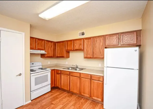 a kitchen with a sink a refrigerator and a stove top oven
