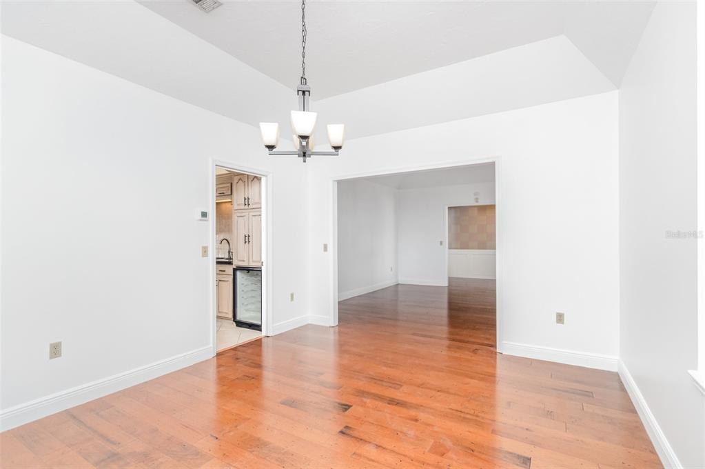9217 Ridge Pine Trail Orlando, FL 32819 - Photo 11 of 37 a view of empty room with wooden floor and chandelier