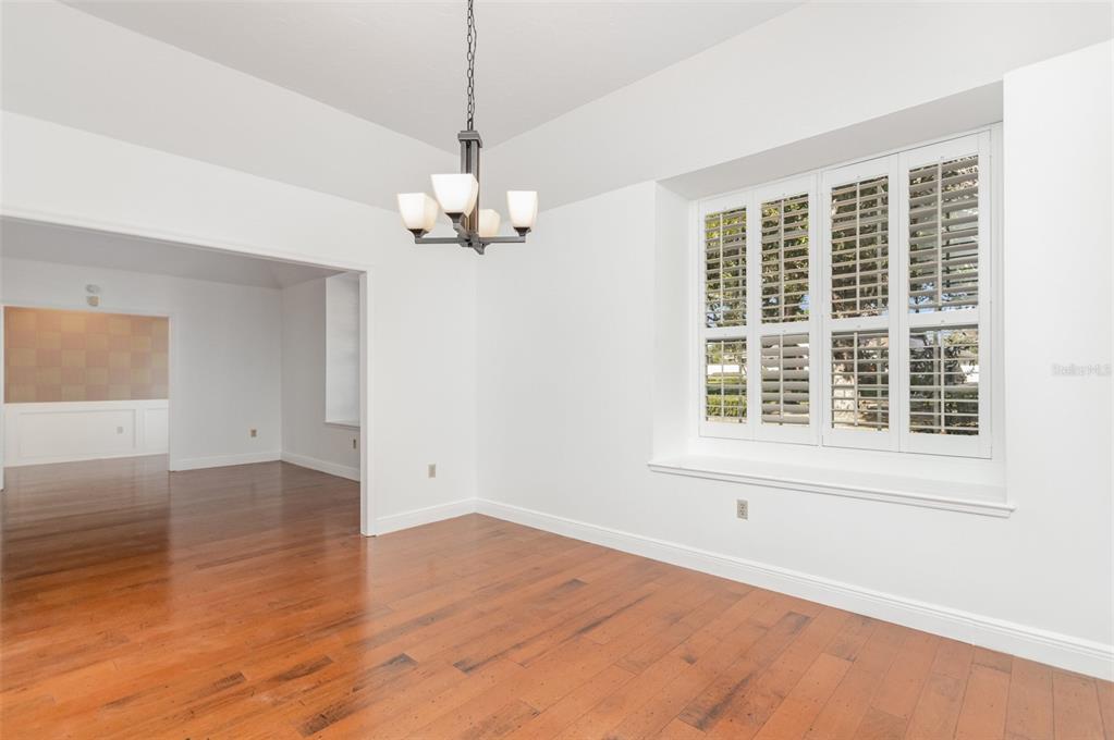 9217 Ridge Pine Trail Orlando, FL 32819 - Photo 12 of 37 an empty room with wooden floor chandelier and windows