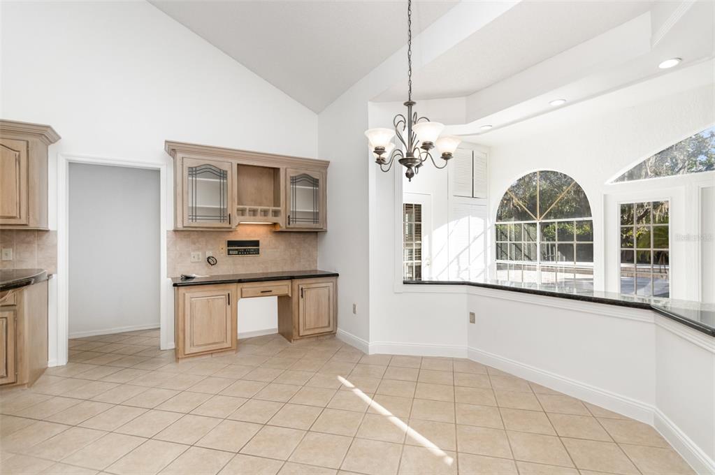 9217 Ridge Pine Trail Orlando, FL 32819 - Photo 12 of 39 a large white kitchen with cabinets a sink a window and stainless steel appliances