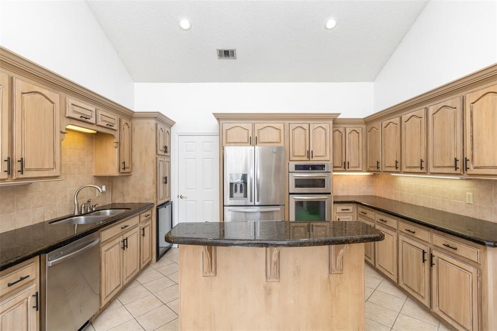 9217 Ridge Pine Trail Orlando, FL 32819 - Photo 14 of 37 a kitchen with stainless steel appliances granite countertop a sink and cabinets