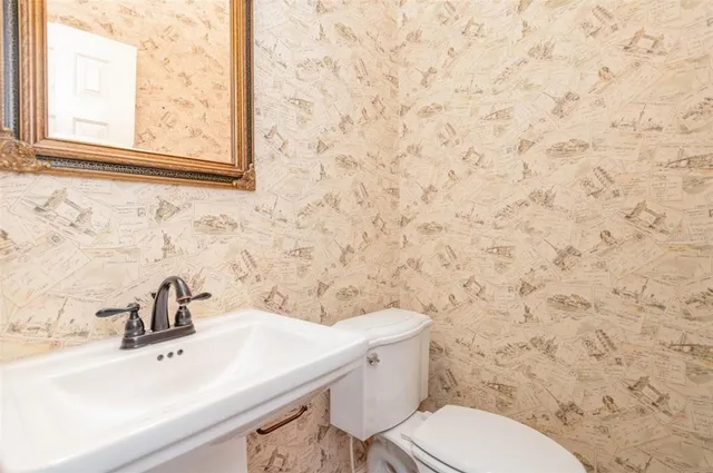 a bathroom with a sink a toilet and a mirror