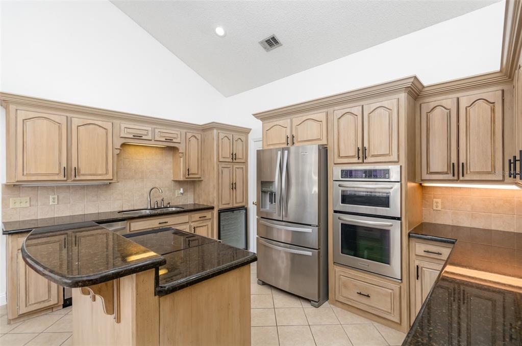9217 Ridge Pine Trail Orlando, FL 32819 - Photo 15 of 37 a kitchen with stainless steel appliances granite countertop a sink stove and refrigerator