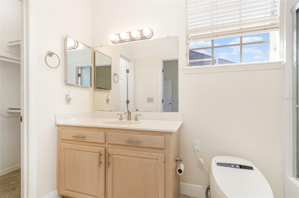 9217 Ridge Pine Trail Orlando, FL 32819 - Photo 30 of 37 a bathroom with a toilet sink and mirror