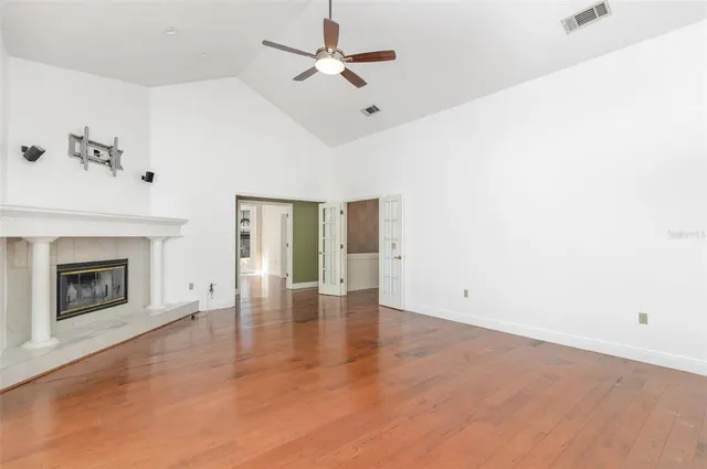 an empty room with fan and fireplace