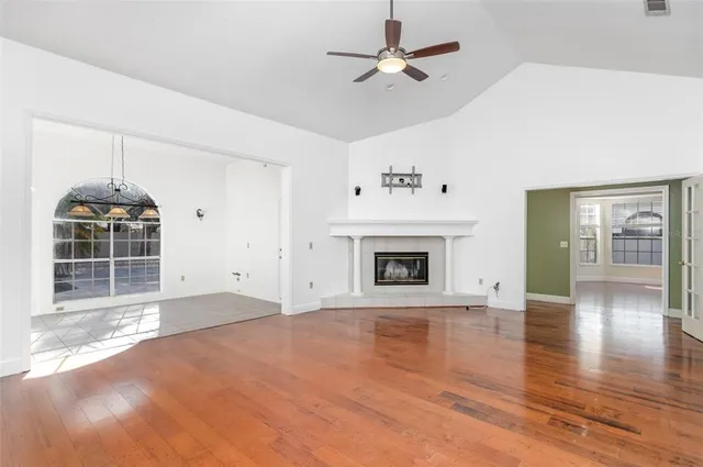 a view of empty room with wooden floor and fireplace
