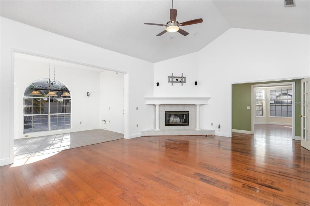 9217 Ridge Pine Trail Orlando, FL 32819 - Photo 6 of 39 a view of empty room with wooden floor and fireplace