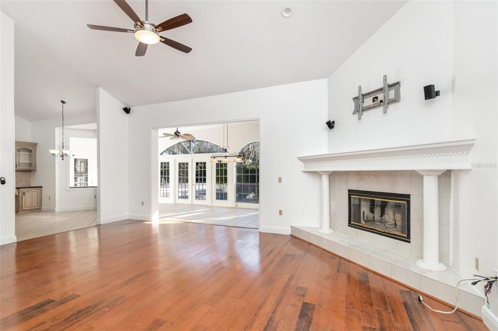 9217 Ridge Pine Trail Orlando, FL 32819 - Photo 7 of 39 a view of an empty room with wooden floor and a fireplace