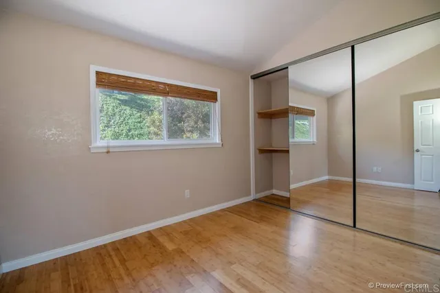 an empty room with wooden floor and a window