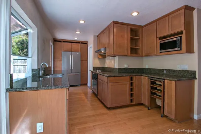 a kitchen with stainless steel appliances granite countertop a stove a sink and a microwave