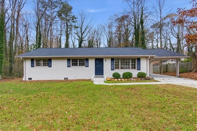 a view of a house with backyard and sitting area