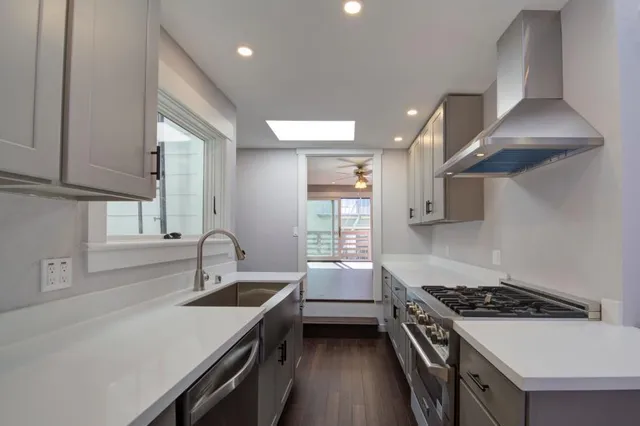 a kitchen with granite countertop a sink stove and cabinets