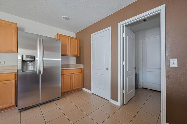a kitchen with a refrigerator sink and cabinets
