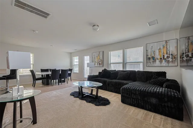 a living room with furniture and floor to ceiling window