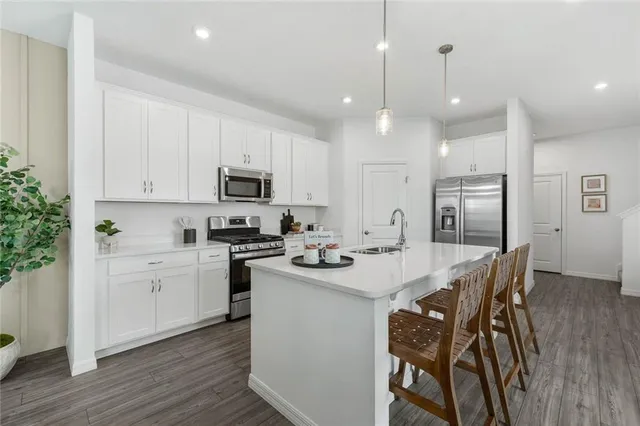 a kitchen with stainless steel appliances kitchen island granite countertop a sink and microwave