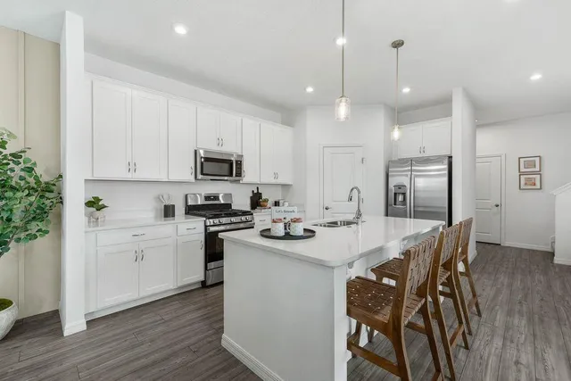 a kitchen with stainless steel appliances kitchen island granite countertop a sink and microwave