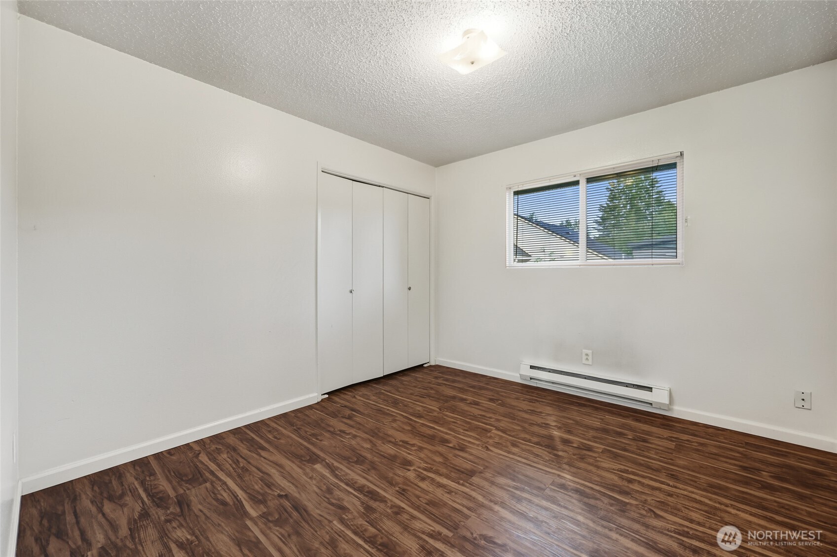 418 North 13th Street Elma, WA 98541 - Photo 12 of 34 an empty room with wooden floor and windows
