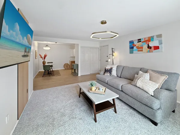 a living room with furniture and a wooden floor