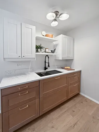 a kitchen with cabinets a window and stainless steel appliances