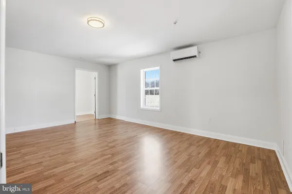 a view of a room with wooden floor and a window