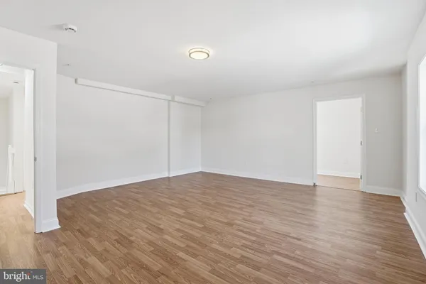 a view of hallway with window and wooden floor