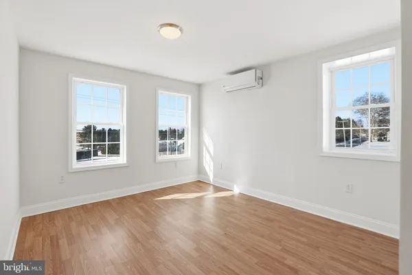 a view of a big room with wooden floor and windows