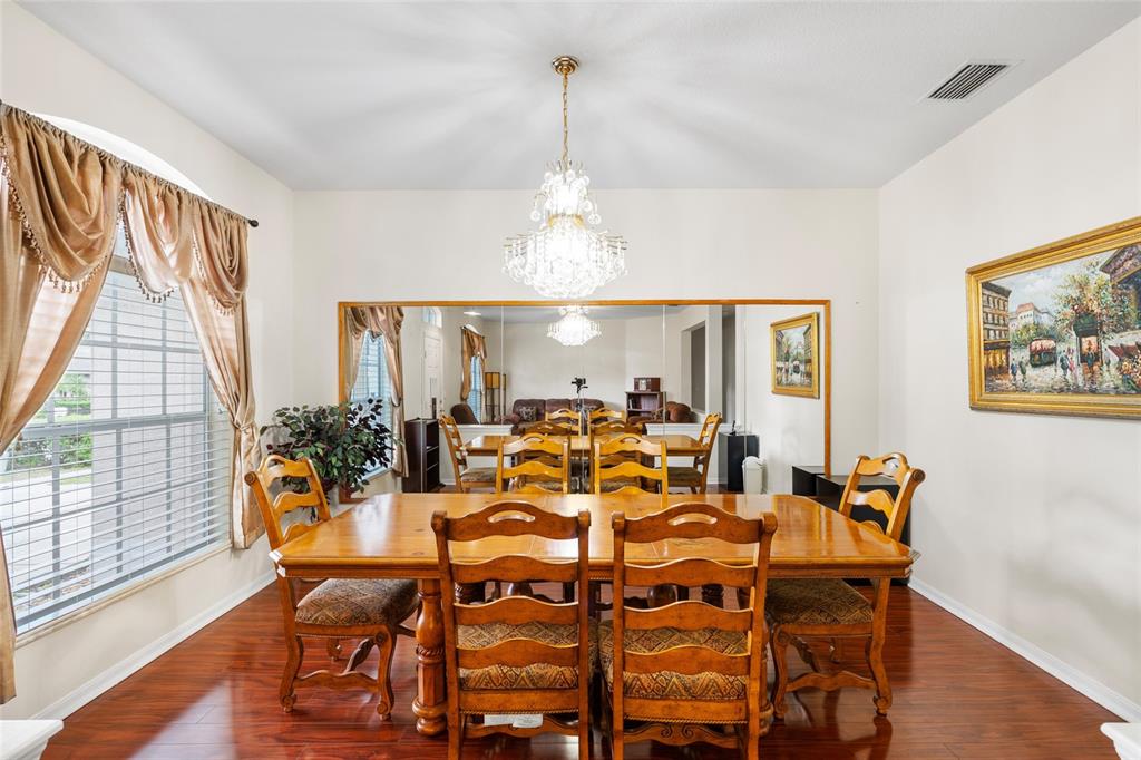 2763 Valencia Grove Drive Valrico, FL 33596 - Photo 12 of 38 a view of a dining room with furniture wooden floor and chandelier